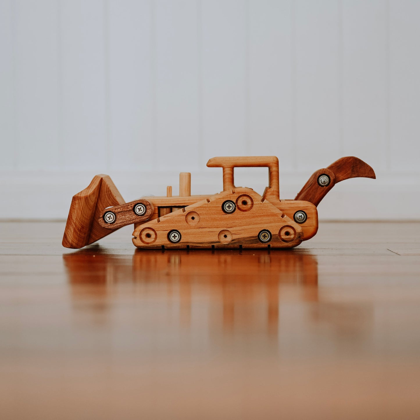 A luxurious Heirloom Wooden digger, showing the functionality of it's handcrafted features such as working ripper, arm and blade.