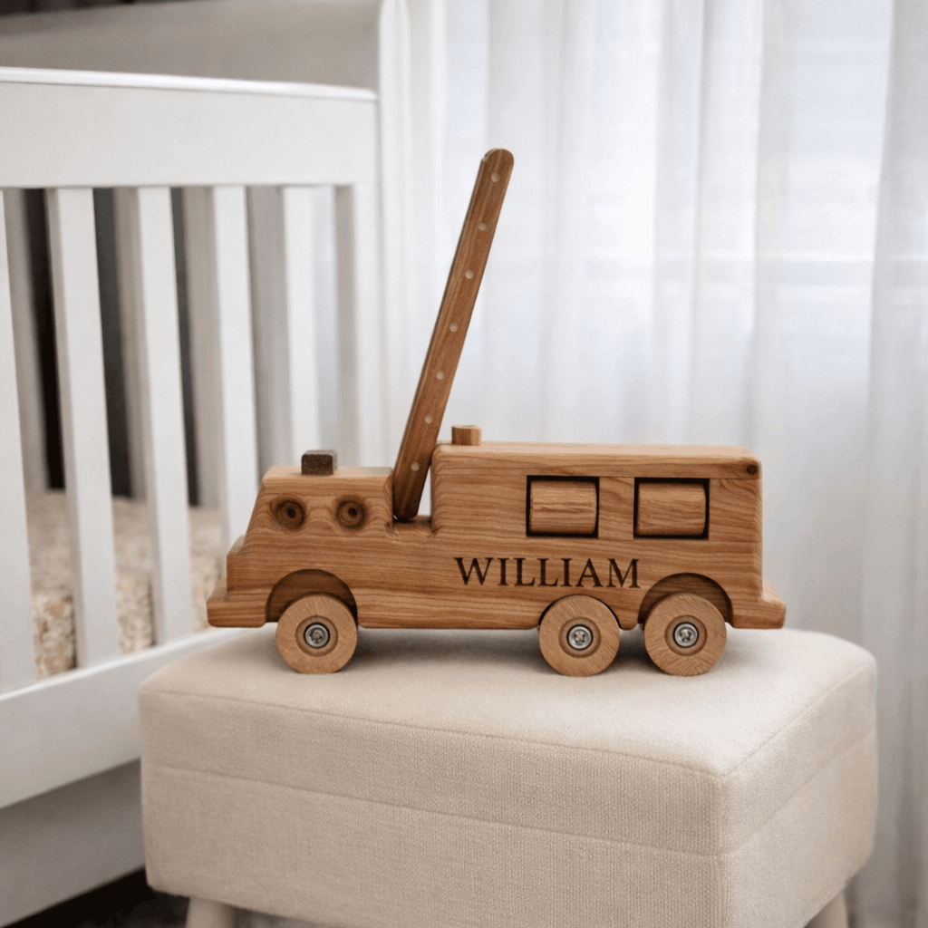 Personalised wooden heirloom firetruck styled in a nursery, engraved with a child’s name.