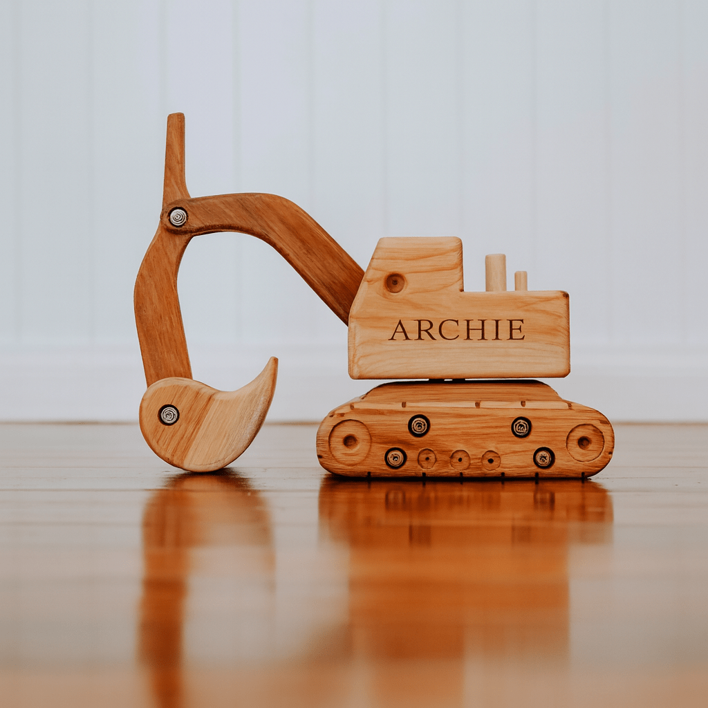 Wooden toy excavator with 'ARCHIE' branding on a reflective surface.