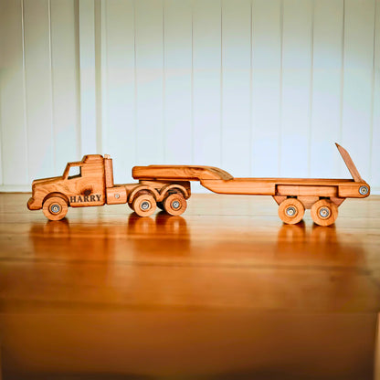 Wooden toy truck with 'HARRY' branding on a wooden surface.