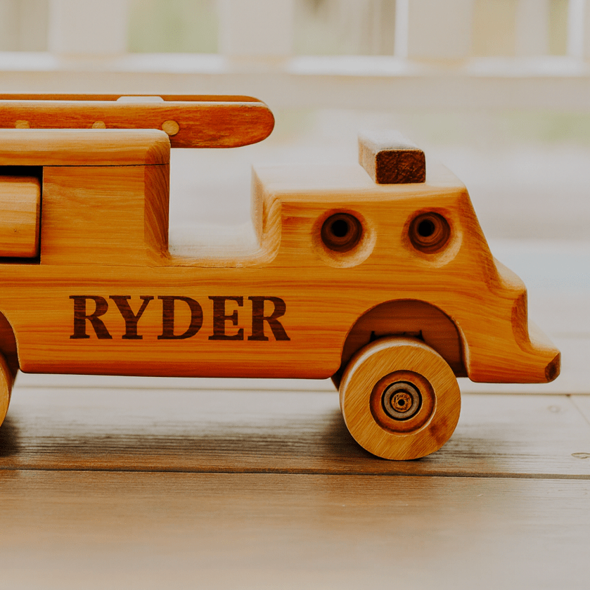 A handmade wooden Firetruck, personalised with the Name "Ryder"