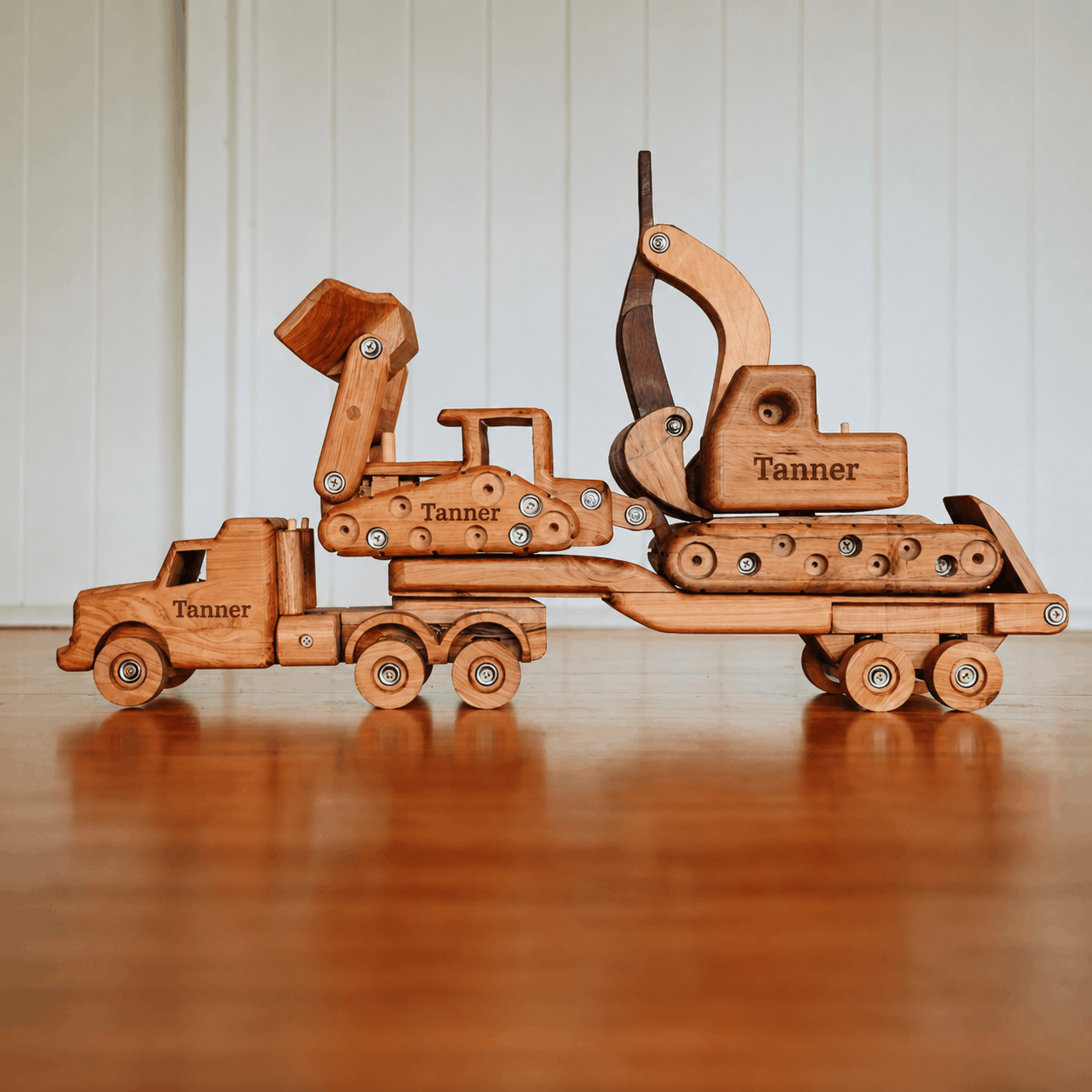 Wooden toy construction set with 'Tanner' branding on a wooden surface.