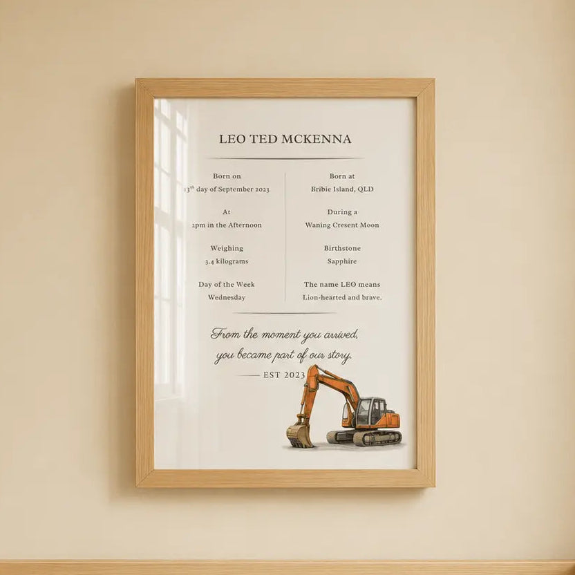 A framed personalized baby nursery sign hanging on a beige wall above a wooden crib. The sign features a construction theme with an excavator illustration and the text 'LIO TED MCKINNA'. excavator