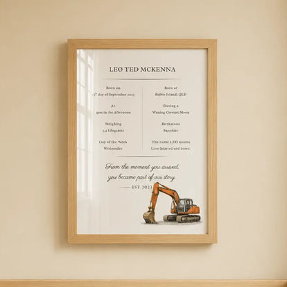 A framed personalized baby nursery sign hanging on a beige wall above a wooden crib. The sign features a construction theme with an excavator illustration and the text 'LIO TED MCKINNA'. excavator