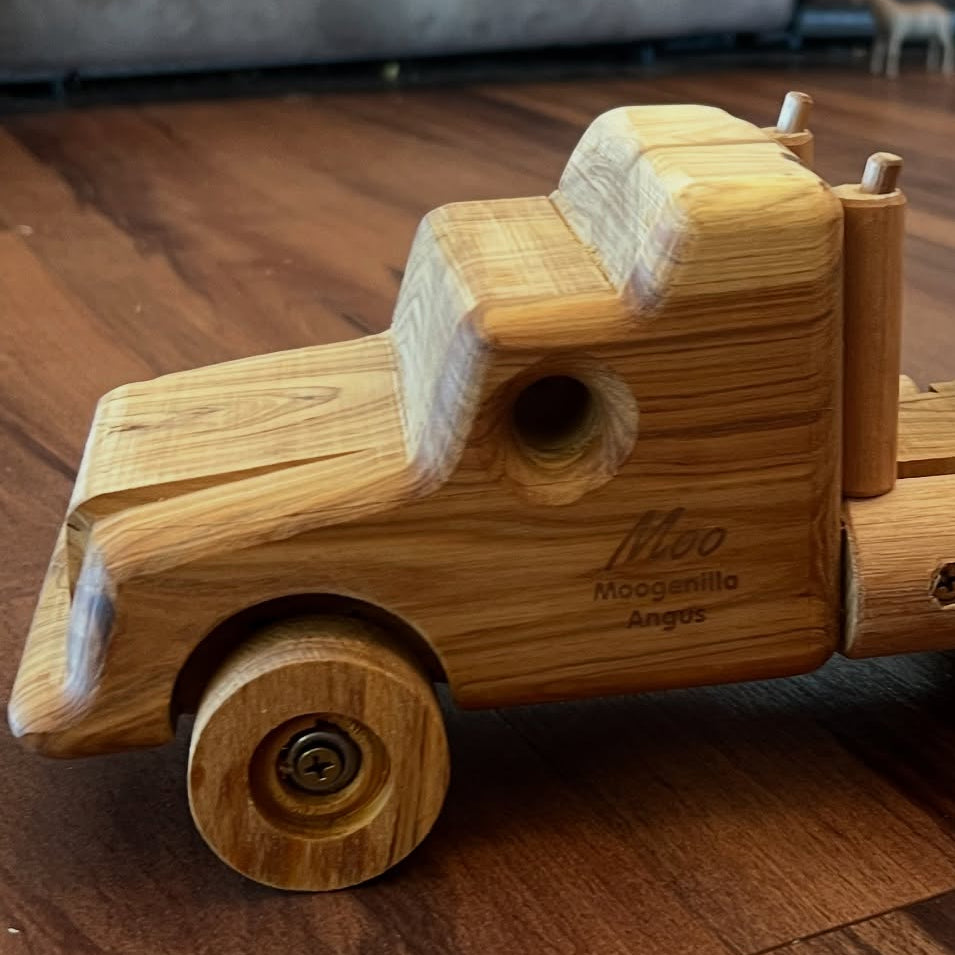 Wooden toy truck with a trailer on a wooden floor