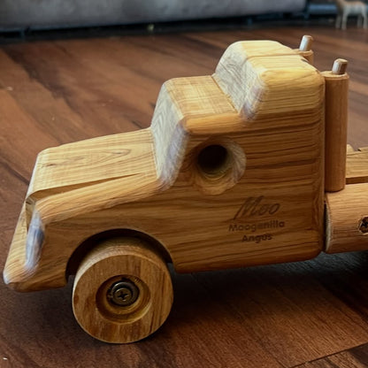 Wooden toy truck with a trailer on a wooden floor