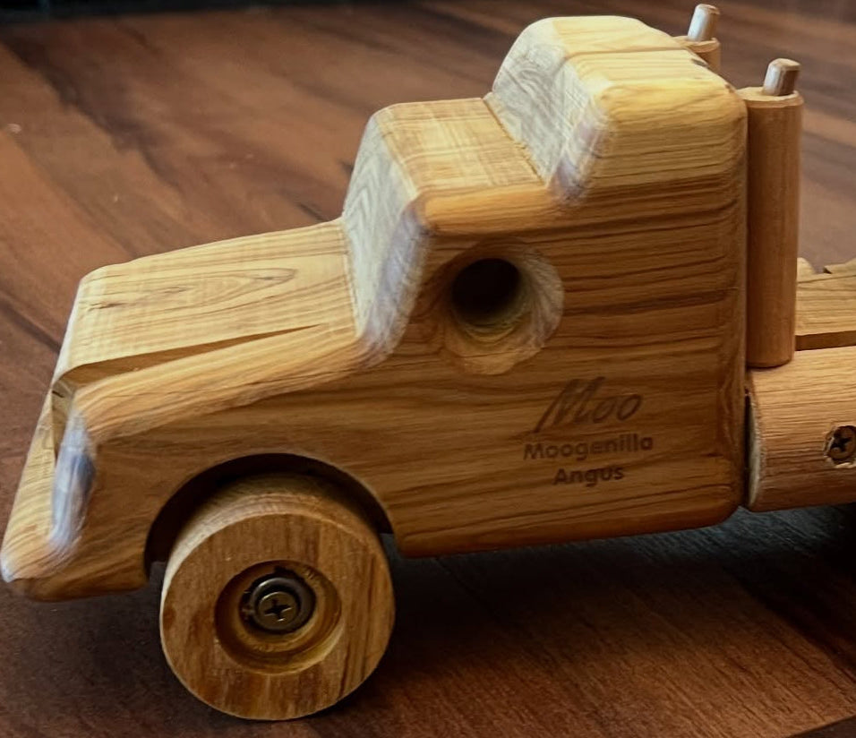 Wooden toy truck with a trailer on a wooden floor