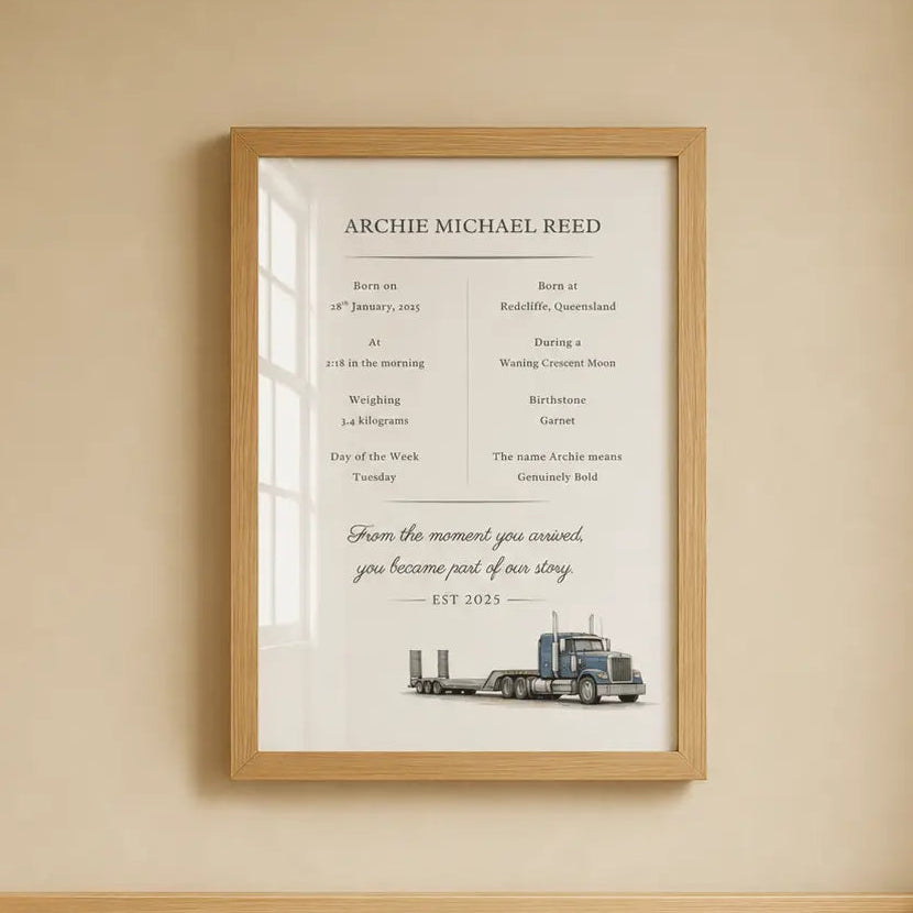 A framed personalized birth memorial print of Archie Michael Reed hangs on a beige wall above a wooden crib with white bedding. Low Loader 