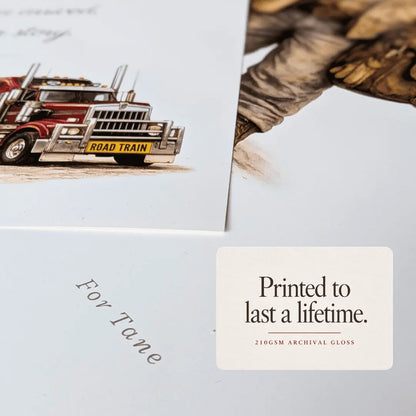 A close-up of a printed archival card or page showing part of an illustrated semi-truck and the text 'For Lane,' with a small label reading 'Printed to last a lifetime. 210GSM ARCHIVAL GLOSS. road train